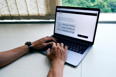 在白桌子上使用macbook pro的人